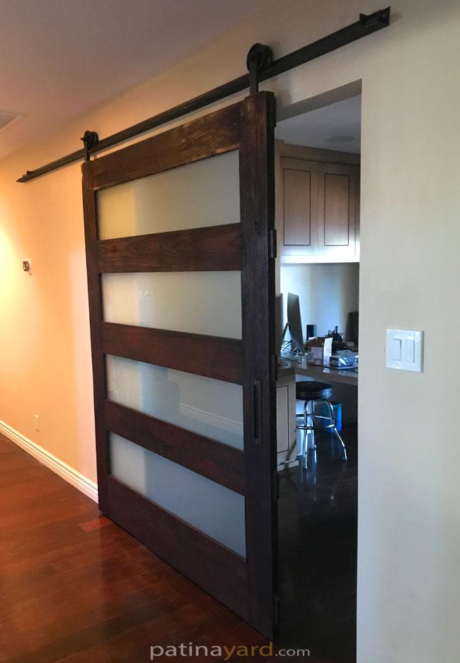 charred wood barn door with opaque glass panels