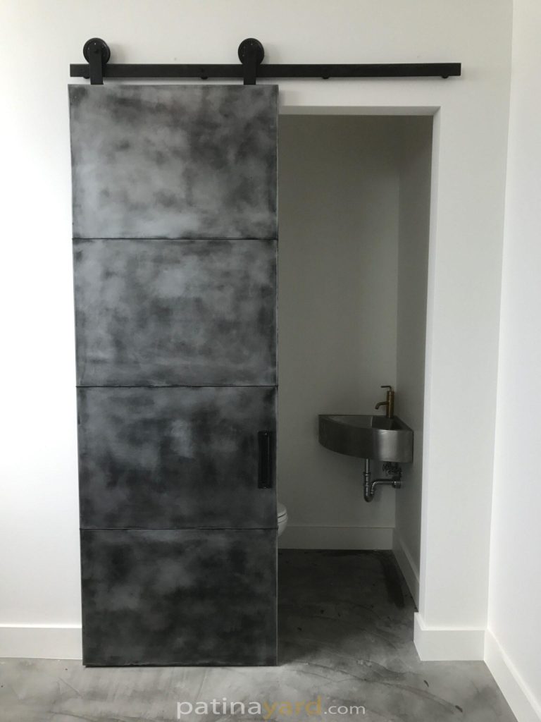 pure zinc panel barn door with an antique black patina finish