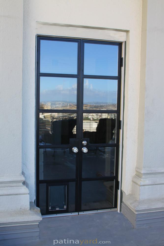 Metal and glass hinged doors with doggie door