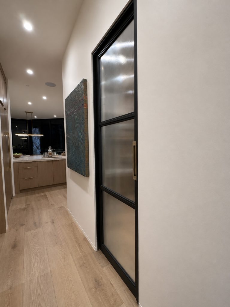 Black metal frame and fluted glass pocket door and brass hardware
