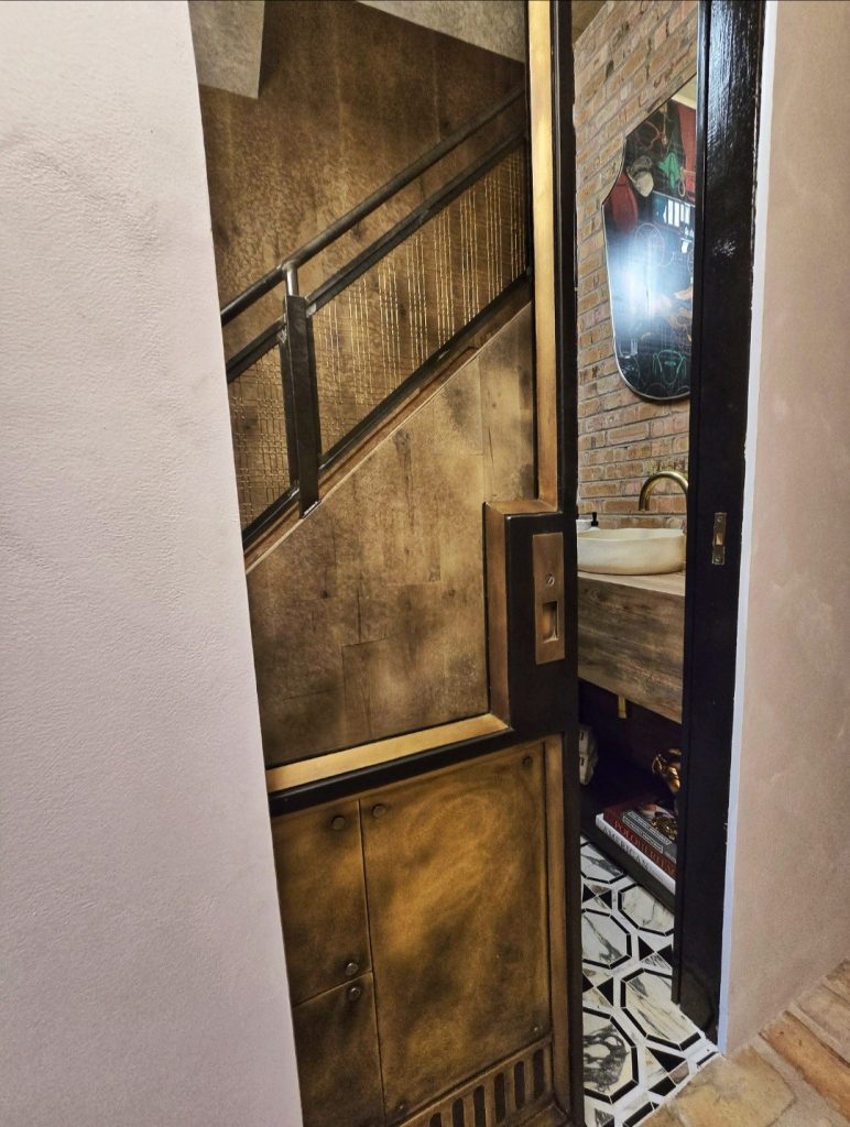 brass and metal pocket door with antique mirror
